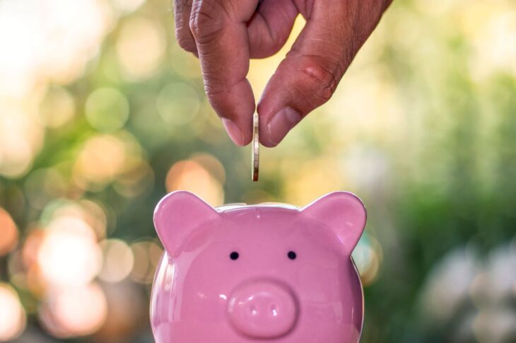 Mackay Financial Planner's hand putting a coin into a piggy bank