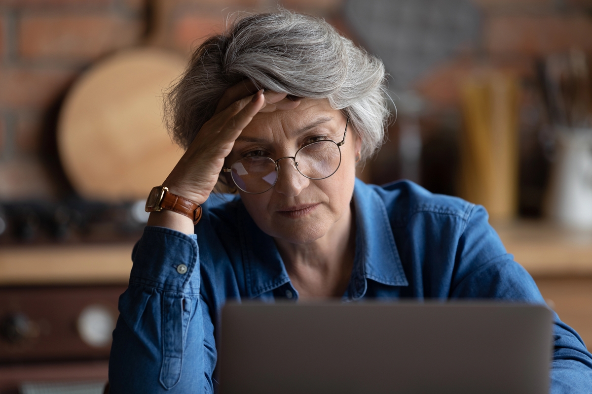 mature woman feels confused experiencing difficulties on laptop